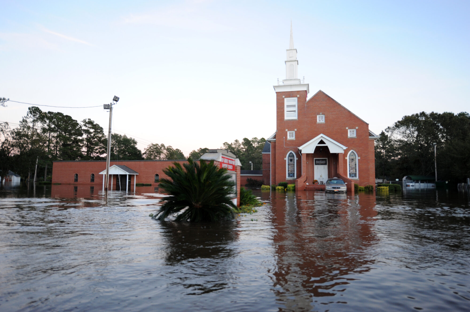 Urban Search and Rescue Teams from Missouri Task Force 1 look for residents that may be stranded in a neighborhood that was flooded following Hurricane Matthew. A brick church is pictured here with water reaching its doors.