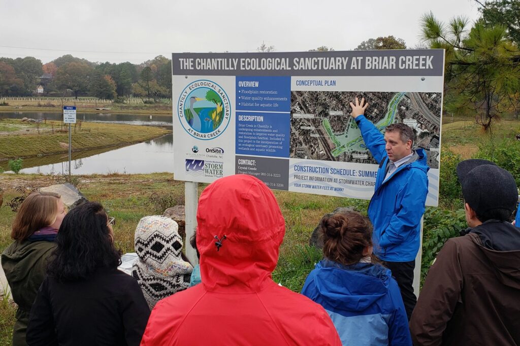 Mecklenburg County Storm Water Engineering & Flood Mitigation Program Manager Tim Trautman explains the county’s buyout program to students in CRC researcher Dr. Gavin Smith’s “Natural Hazards and Climate Change” course during a trip to Charlotte on Nov. 9, 2018. Trautman explained the process by which half of an apartment complex east of downtown Charlotte was bought out and converted to a public park in the floodplain, increasing the value of some nearby homes. Photo by Josh Kastrinsky.