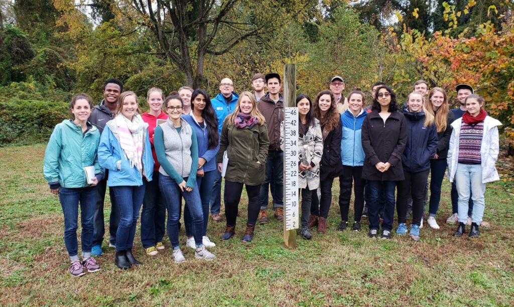 Dr. Smith’s class poses at a flood gauge during the final stop of their tour of buyout and retrofit projects in Charlotte. Photo by Josh Kastrinsky.